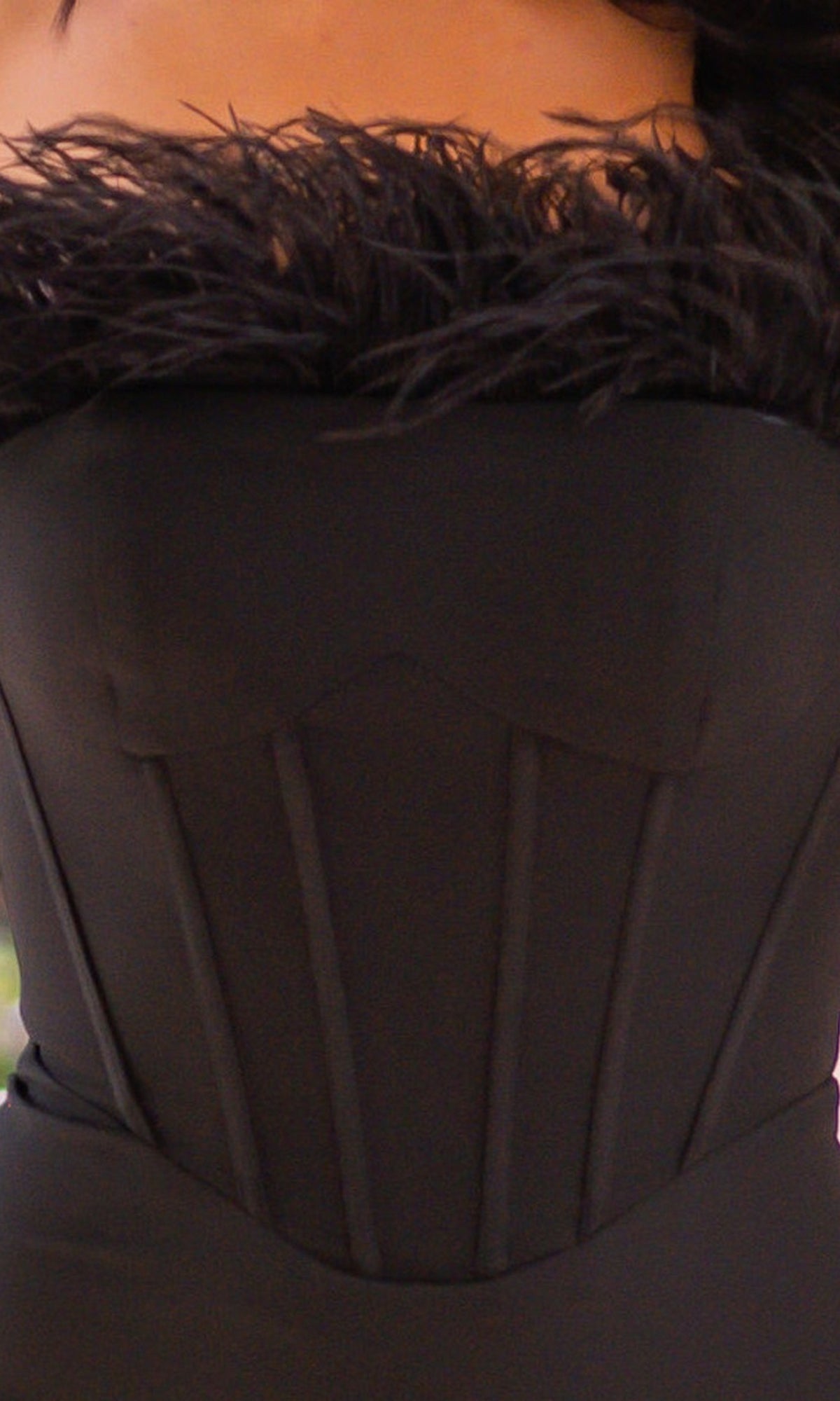 Close-up of the Velvi Feathered Strapless Long Prom Dress Sloane in black, featuring a lace-up back, feather trim along the strapless neckline, and vertical seam detailing on the bodice.